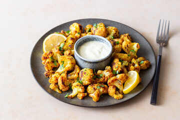 Fried cauliflower with lemon, herbs and white sauce. Healthy eating. Vegetarian food.