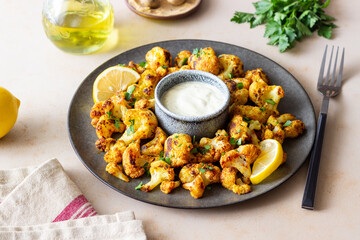 Fried cauliflower with lemon, herbs and white sauce. Healthy eating. Vegetarian food.
