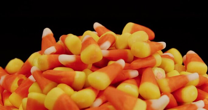 Candy corn falling on pile in slow motion on spinning turntable