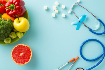 Managing diabetes with a balanced diet. Top view shot of a blue ribbon, insulin syringes, stethoscope, sugar cubes and a plate of healthy fruits and veggies on a pastel blue backdrop with ad space