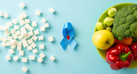 Stay mindful during Diabetes Awareness Month. Top view of emblem - blue ribbon with blood drop, set...