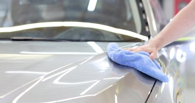 Man cleaning car with microfiber cloth. Car wash services concept