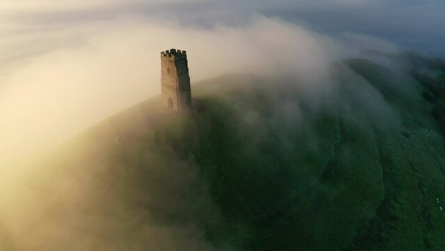 Aerial of Glastonbury Tor on a misty autumn morning above the Somerset Levels, Somerset, England