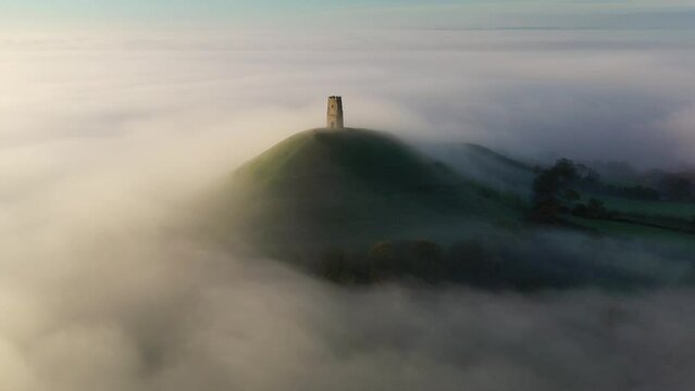 Aerial of Glastonbury Tor on a misty autumn morning above the Somerset Levels, Somerset, England
