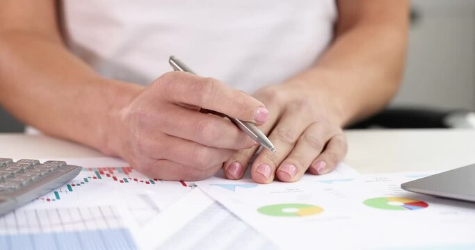 Female hands holding ballpoint pen at table with graphs and diagrams 4k movie. Profit growth business strategies concept