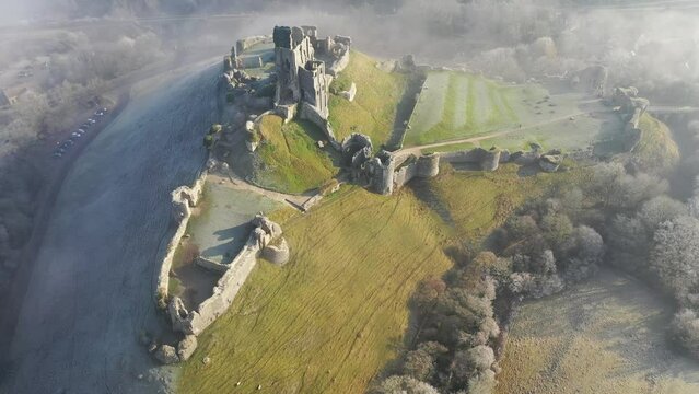 Aerial of Corfe Castle at dawn on a chilly frosty winter morning, Corfe, Dorset, England