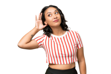 Young Argentinian woman over isolated background listening to something by putting hand on the ear