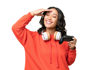 Young Argentinian woman playing with a video game controller over isolated background smiling a lot © luismolinero