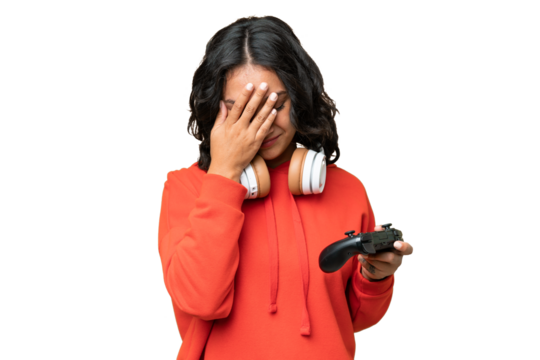 Young Argentinian woman playing with a video game controller over isolated background with tired and sick expression
