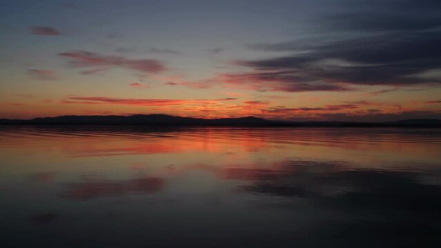 Landscape of an autumn sunset on a lake with calm water. Mirror reflection of the sky on the water. Natural landscape.