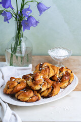 Heap of freshly baked homemade traditional Swedish cinnamon buns ( knots) on beautiful oval white plate. 