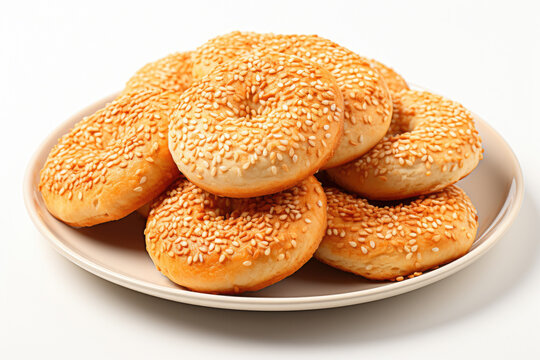 Plate of sesame bagels is displayed on white table. This image can be used to showcase delicious breakfast spread or for food-related content.