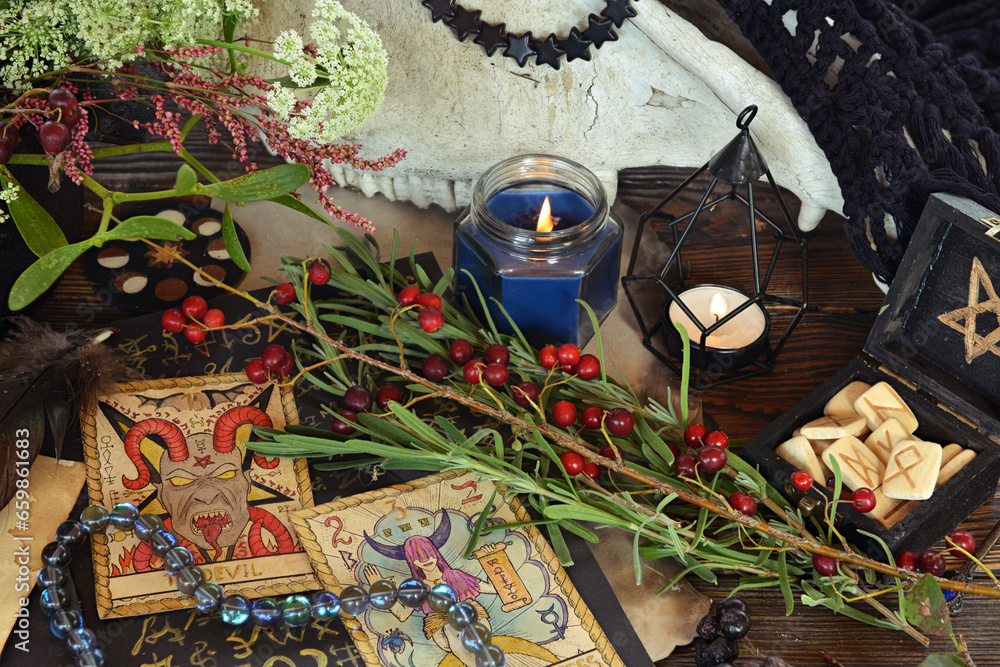 Wall mural Tarot cards and runes with candles on altar witch table. Occult, esoteric and divination still life. Mystic Halloween background with vintage objects for magic ritual