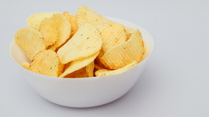 Potato Chips in a white plate on a white background.
