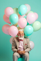 Fototapeta na wymiar Happy old man posing on his birthday with balloons