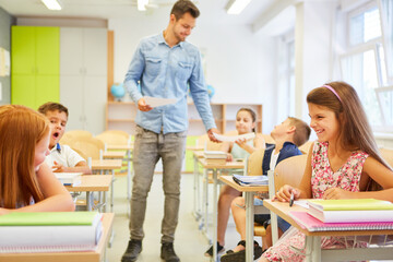 Happy students having fun with teacher in classroom
