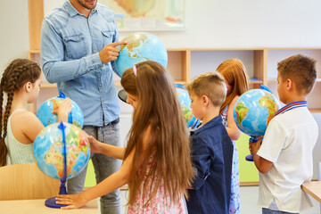 Students learning through globes in class