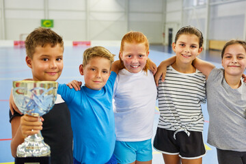 Group of students with trophy in school gym