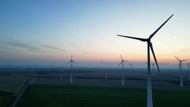 Schöner Blick auf einen großer Windpark. Mehrere Windturbinen erzeugen regenerative Energie in der Dämmerun. Fantastischer Rundblick über mehrere Windkraftwerk. Nahaufnahme Windturbine