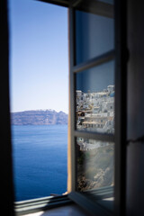 Townscape touristic village reflected on a window glass with a beautiful scenic of Santorini, Greek Islands