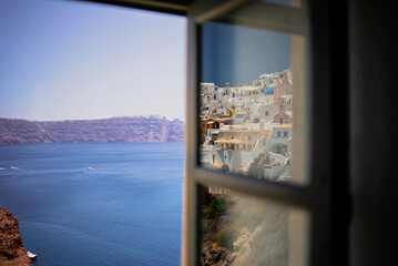 Townscape touristic village reflected on a window glass with a beautiful scenic of Santorini, Greek Islands - obrazy, fototapety, plakaty