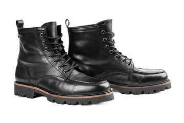 Pair of black leather boots, dress boots for men, men ankle high boots. Black brogue boots on a white background. Men fashion in leather boots. Man's legs in black jeans and brown leather boots.