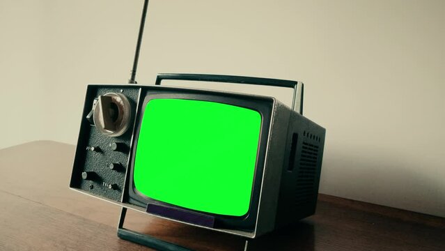Retro TV Green Screen Interference Compact Old Television Zoom In. Old compact retro television with green screen interference on the table of a house, zoom in