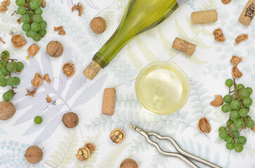 Autumn harvest: wine, green grapes nuts on a table, flat lay. 