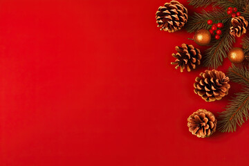 Fototapeta na wymiar Christmas composition. Christmas fir tree branches, christmas ball, pine cones on red background with blank space for text