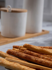 Cheese Sprinkle Stick Cookies are neatly presented on a white plate with attractive decorations. They are isolated against a white background.
