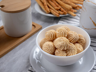 Sago Cookies are neatly presented in a white bowl with an attractive arrangement. They are isolated against a white background in a dining table setting.