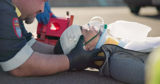 Hands, medical emergency and a paramedic team with a patient or victim on the street for accident treatment. Healthcare, oxygen or first aid with an emt and colleague working to rescue a person