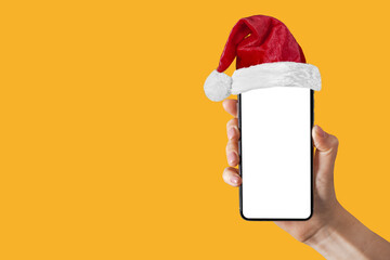 phone in a hand with a Santa Claus hat for Christmas