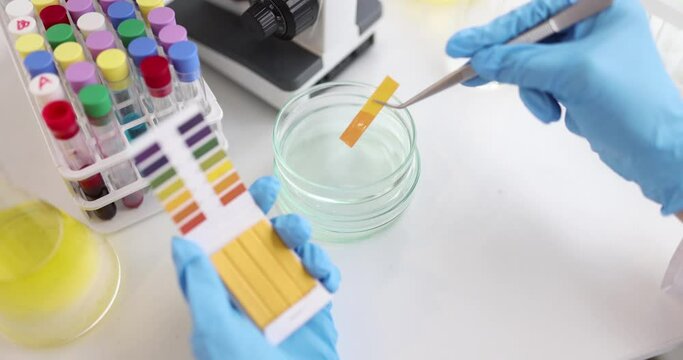 Biologist checks PH test by chemical alkaline analysis in laboratory. Biotechnology and medicine concept.