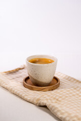 Cup of coffee served on a cloth on a wooden table—a simple and aesthetic concept.