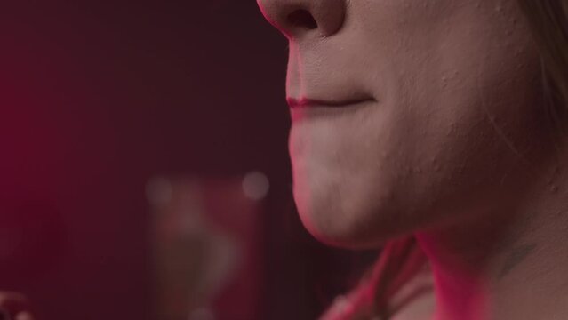 Close up of queer man applying brown matte lipstick while doing makeup in backstage room before drag show