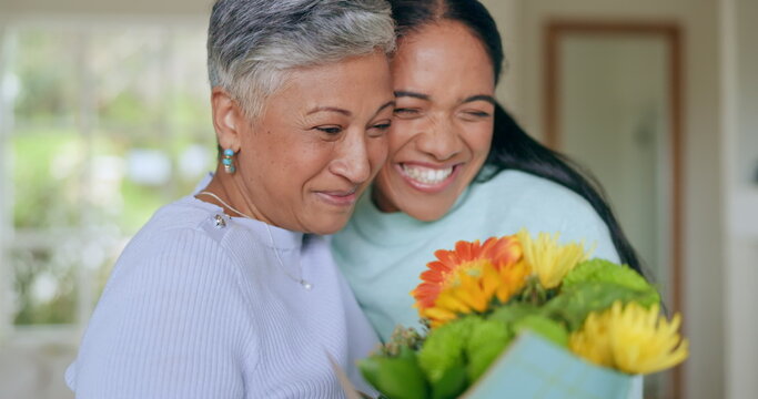 Happy, mothers day and woman with flowers for surprise, gift and love for family, support and care in home. Wow, thank you and mom with floral, present and person giving parent a bouquet in house