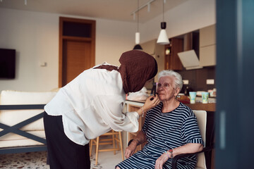 Fototapeta premium In this heartwarming real-life scene, a girl in a hijab and her sister lovingly apply makeup to their elderly grandmother, preparing her for a special family anniversary celebration, showcasing the