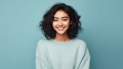 Fototapeta premium A radiant teenage girl beaming with happiness against a soft studio backdrop.