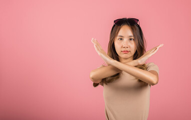 Portrait Asian beautiful young woman unhappy or confident standing holding two cross arms say no X...