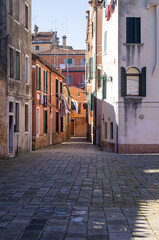 Fototapeta na wymiar Venitian architecture, no one, no people, buildings, daylight. Residential area. Venice, Italy. Old town, facade. Residential neighborhood. Romantic street, clear sky. Drying cloth on a rope. life