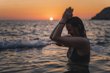 Young cheerful relaxed woman in a natural sea bath on the seashore. Thalassotherapy wellness concept - obrazy, fototapety, plakaty