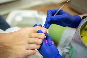 concept of male pedicure, cosmetologist makes classic pedicure for an elderly male client.