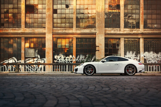 Brno, Czech Republic - September 7 2016: A white Porsche 911 Carrera S MK2  991.2 parked next to an old abandoned building