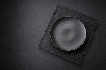 Empty ceramic round plate on dark textured concrete background