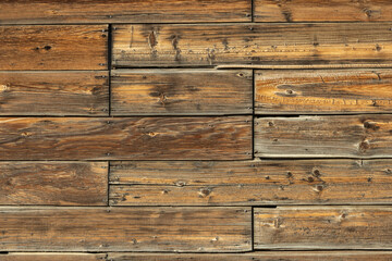 Closeup background texture image of the woodgrain and patterns in weathered old barnwood.