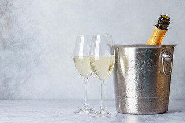 Two champagne glasses and bottle in ice bucket