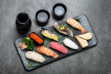 omakase mixed sushi set with sake on grey background - 659921470
