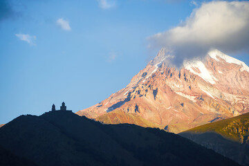 The view of the Kazbeg peak behind the clouds and the Cminda Sameba chapel. 