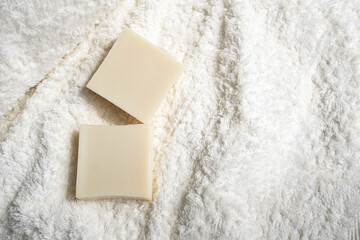 two bars of soap lie on a towel